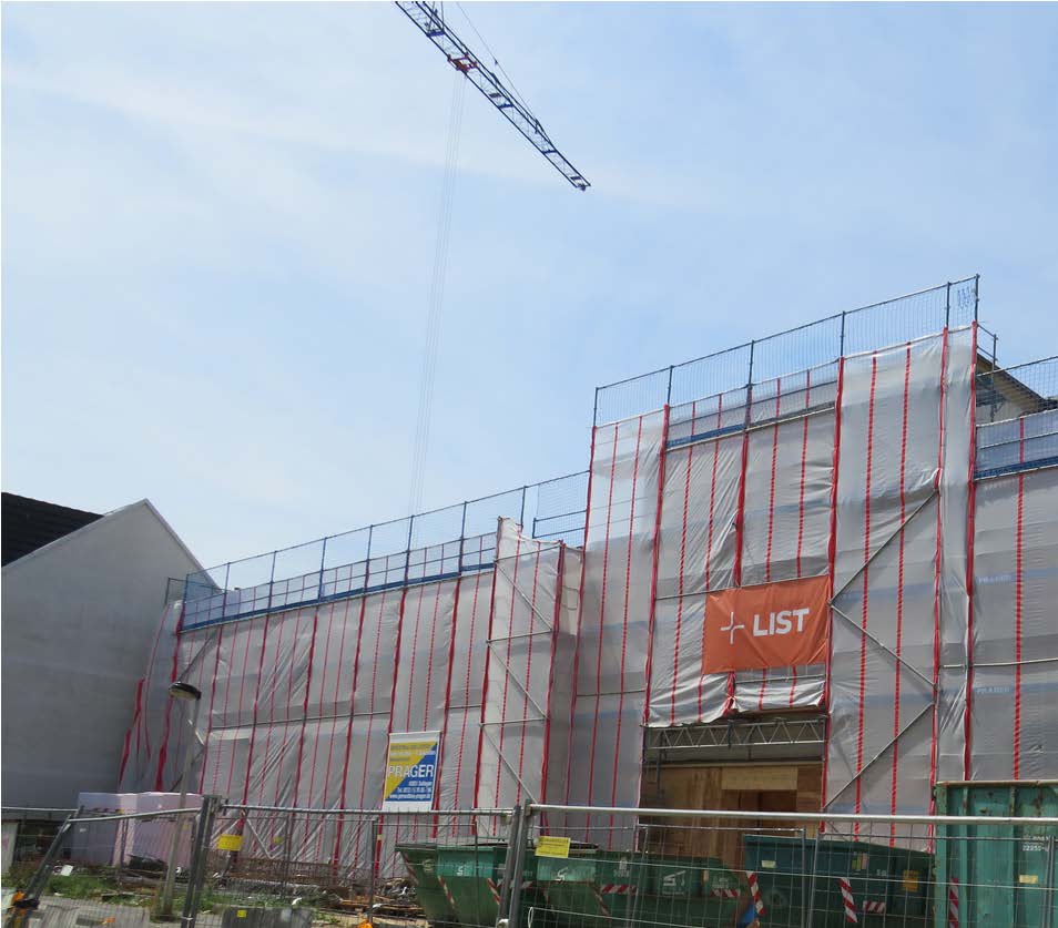 Die eingerüstete Baustelle der Grundschule am Kreuzweg mit Kran im Hintergrund