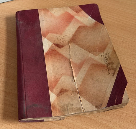 Ein altes, ramponiertes Heft mit ledernem Einband, das hinter einer Wand gefunden wurde