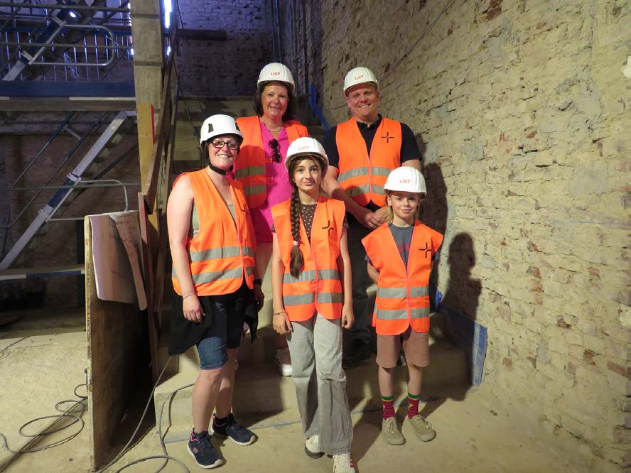 Unser Reporter-Team gemeinsam mit der Bauleitung, alle mit Helm und Warnweste